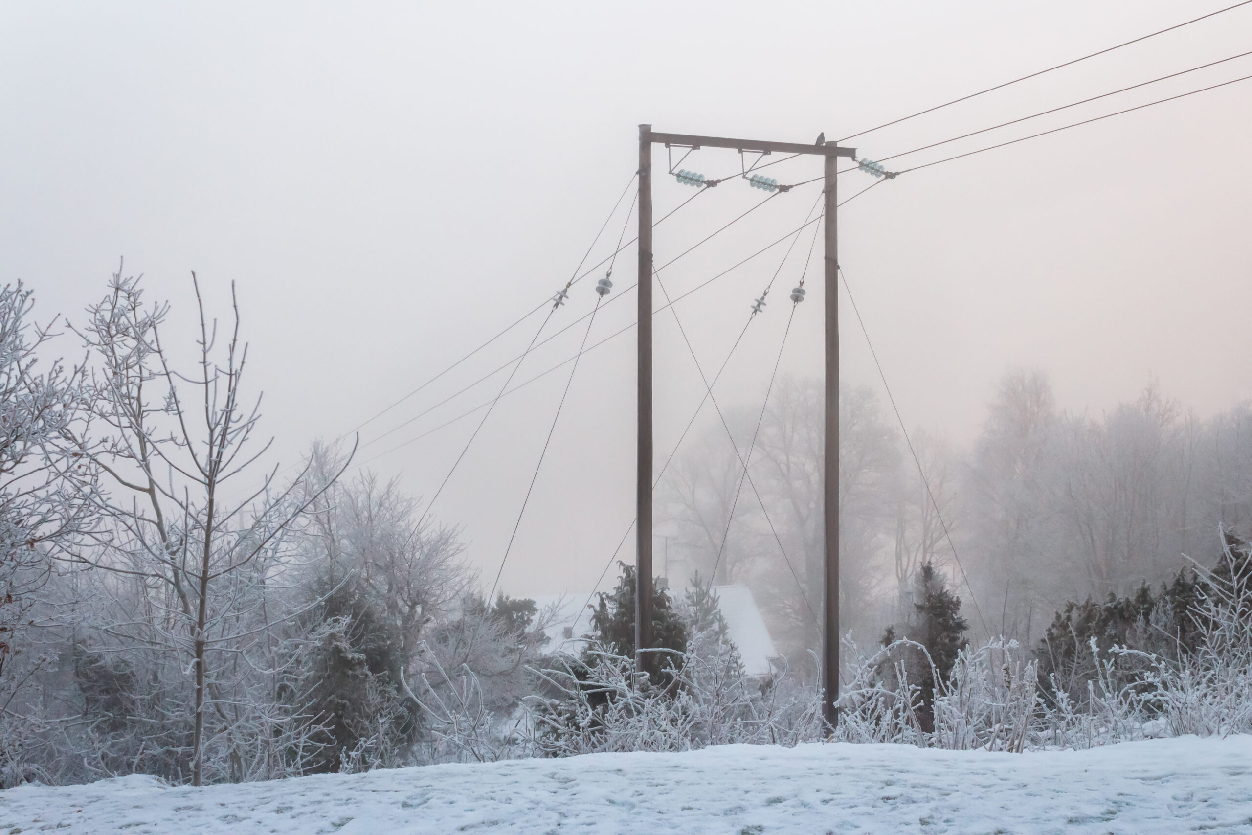 Pylône de ligne électrique dans le givre et le brouillard
